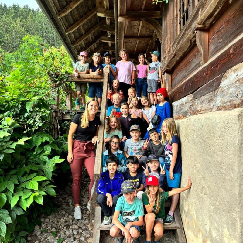 Klasse 2b mit Lehrerin auf einer Treppe im Freilichtmuseum Vogtsbauernhof