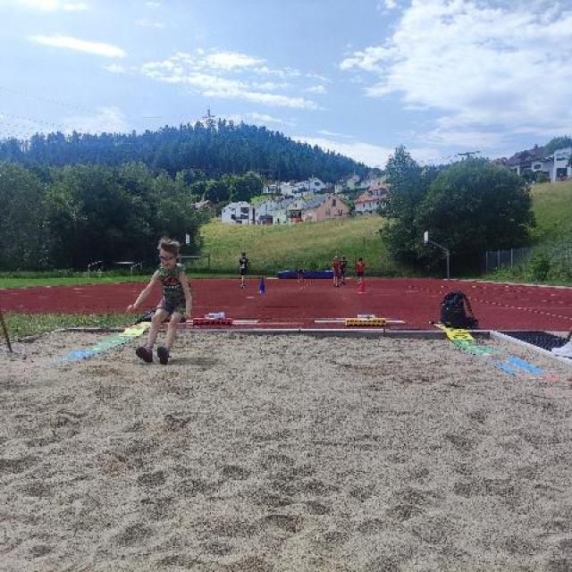 Schüler beim Weitsprung auf dem Sportplatz